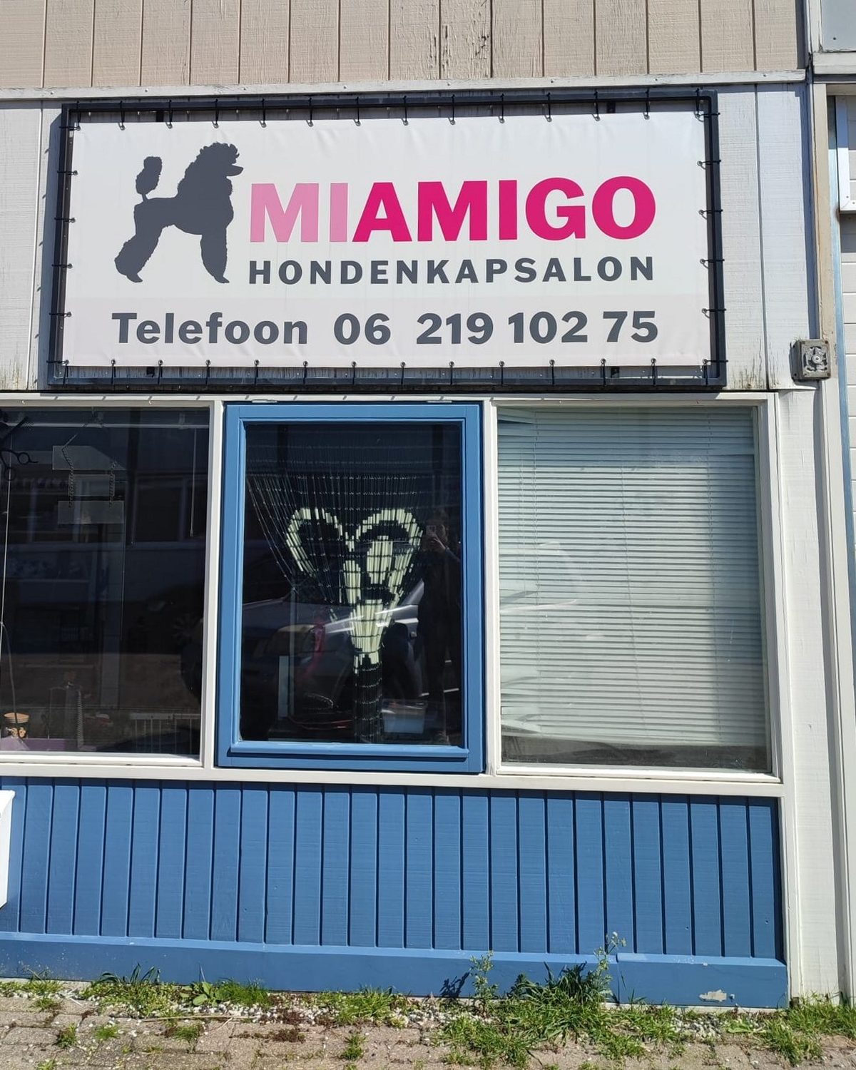 De voorkant van Hondenkapsalon Miamigo met het bord met de poedel en het telefoonnummer